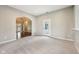 Spacious living room with carpet flooring, white trim, and an open doorway to a foyer featuring a chandelier at 10444 Indian Lake N Blvd, Indianapolis, IN 46236