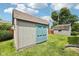A storage shed with dual doors is situated in a well-maintained backyard at 10444 Indian Lake N Blvd, Indianapolis, IN 46236