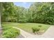 Lush, well-maintained backyard with mature trees, manicured bushes, and scenic green space at 10808 Greenbriar Dr, Fishers, IN 46037