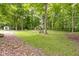 Picturesque backyard featuring a fire pit, mature trees, and serene natural setting at 10808 Greenbriar Dr, Fishers, IN 46037