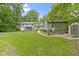 Expansive backyard view showcasing a lush lawn, deck, mature trees, and outdoor shed at 10808 Greenbriar Dr, Fishers, IN 46037