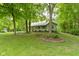 Quaint one-story home nestled among mature trees, featuring a covered front porch and established landscaping at 10808 Greenbriar Dr, Fishers, IN 46037