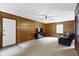 Living room with paneled walls, carpeting, and a ceiling fan at 10808 Greenbriar Dr, Fishers, IN 46037