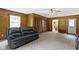 Comfortable living room with wood paneled walls and cozy gray carpeting at 10808 Greenbriar Dr, Fishers, IN 46037