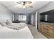 Comfortable main bedroom with gray walls, ceiling fan, and large dresser with mounted television at 10808 Greenbriar Dr, Fishers, IN 46037