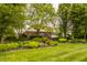 Gorgeous backyard featuring mature trees, flowerbeds, manicured lawn, and professional landscaping at 11875 Durbin Dr, Carmel, IN 46032