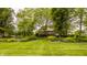Beautifully landscaped backyard with vibrant flowerbeds, mature trees, and lush green lawn at 11875 Durbin Dr, Carmel, IN 46032