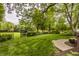 Expansive backyard featuring manicured lawn, mature trees, and decorative iron fencing at 11875 Durbin Dr, Carmel, IN 46032