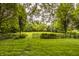 Lush backyard with black iron fence, mature trees, and expansive green space at 11875 Durbin Dr, Carmel, IN 46032