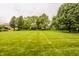 Expansive backyard view showcasing well-maintained lawn, mature trees, and landscaping at 11875 Durbin Dr, Carmel, IN 46032