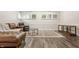 Basement area featuring leather sofa and recliner, glass coffee table, decorative rug, and white wainscotting at 11875 Durbin Dr, Carmel, IN 46032
