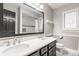 Bright bathroom with double vanity, modern fixtures, and a large framed mirror reflecting the shower at 11875 Durbin Dr, Carmel, IN 46032