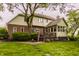 Back exterior view showcasing a multi-level deck, screened porch, brick, and lush landscaping at 11875 Durbin Dr, Carmel, IN 46032