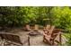 Inviting outdoor brick fire pit and seating area, surrounded by lush trees and landscaping at 11875 Durbin Dr, Carmel, IN 46032