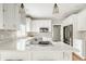 Clean, bright kitchen featuring white cabinets, an island cooktop, and modern stainless steel appliances at 11875 Durbin Dr, Carmel, IN 46032