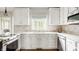 Bright, modern kitchen with white cabinets, stone countertops, and a stylish tile backsplash at 11875 Durbin Dr, Carmel, IN 46032