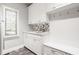 Bright laundry room with white cabinetry, modern fixtures, and gray tiled floor at 11875 Durbin Dr, Carmel, IN 46032