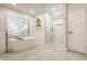 Bright bathroom featuring a soaking tub, a walk-in shower, and light wood-look tile floors at 11875 Durbin Dr, Carmel, IN 46032