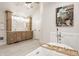 Spa-like main bathroom boasting a freestanding tub, a walk-in shower, and wooden cabinets at 11875 Durbin Dr, Carmel, IN 46032