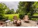 Charming outdoor patio featuring cozy seating, a small table, and views of the expansive lawn at 11875 Durbin Dr, Carmel, IN 46032
