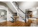 Elegant staircase featuring wood steps, black banister, and white risers complements the hardwood floors at 11875 Durbin Dr, Carmel, IN 46032
