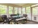 Sunroom features wicker furniture, a glass top table, a colorful rug, and bright, airy windows at 11875 Durbin Dr, Carmel, IN 46032