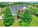 Aerial view of a two-story red brick home with a dark roof and mature trees surrounding the property at 12635 Tuscany Blvd, Carmel, IN 46032