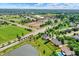 Aerial view of the surrounding neighborhood showcasing a school, sports fields, a pond, and mature trees at 12635 Tuscany Blvd, Carmel, IN 46032