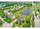 Aerial view of homes in a neighborhood, featuring a pond, mature trees, and easy access to main road at 12635 Tuscany Blvd, Carmel, IN 46032
