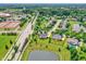Aerial view of the homes in a neighborhood featuring mature trees, ponds, and community tennis courts at 12635 Tuscany Blvd, Carmel, IN 46032