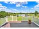 Beautiful backyard view from deck showing white fence, landscaping, and pond at 12635 Tuscany Blvd, Carmel, IN 46032