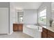 Bright bathroom featuring a large tub, vanity, and natural light from the window at 12635 Tuscany Blvd, Carmel, IN 46032