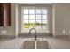 Bright double kitchen sink under a window provides a view, complemented by a sleek faucet at 12635 Tuscany Blvd, Carmel, IN 46032