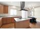 Well-lit kitchen with an island cooktop and stainless steel hood at 12635 Tuscany Blvd, Carmel, IN 46032