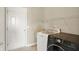 Functional laundry room with modern washer and dryer units, shelving, and ample space for cleaning tasks at 12635 Tuscany Blvd, Carmel, IN 46032