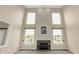 Spacious living room featuring a fireplace, high ceilings, and large windows overlooking the lush yard at 12635 Tuscany Blvd, Carmel, IN 46032