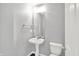 A well lit powder room features a pedestal sink, toilet, and a mirrored wall, ideal for guests at 12635 Tuscany Blvd, Carmel, IN 46032