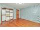 Bedroom featuring hardwood floors, geometric wallpaper, and closet at 138 Plaza Chica St, Greenwood, IN 46143
