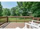Relaxing deck with a wood railing offers serene views of mature trees and lush green landscape at 138 Plaza Chica St, Greenwood, IN 46143