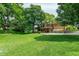 Well-manicured front yard featuring mature trees, a charming exterior, and a spacious green lawn at 138 Plaza Chica St, Greenwood, IN 46143