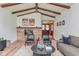 Living room with vaulted ceilings, wood beams, a brick fireplace, and comfortable seating arrangement at 138 Plaza Chica St, Greenwood, IN 46143