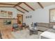 Cozy living room features a brick fireplace, hardwood floors, wood beams, and comfortable seating at 138 Plaza Chica St, Greenwood, IN 46143