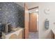 Bathroom featuring custom floral wallpaper and unique vanity adjacent to a door leading to the shower and toilet at 1524 Northcrest Dr, Anderson, IN 46012