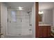 Bathroom showcasing a bathtub with glass doors and tiled shower, next to a vanity with cabinets and mirror at 1524 Northcrest Dr, Anderson, IN 46012