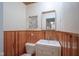 Bathroom featuring white vanity and sink with wood trim, complemented by beadboard paneling, and modern lighting at 1524 Northcrest Dr, Anderson, IN 46012