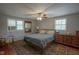 A cozy bedroom with natural light from two windows, wood furniture, and a decorative area rug at 1524 Northcrest Dr, Anderson, IN 46012