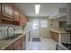 Well-lit kitchen with ample counter space, white appliances, and view to back door and window at 1524 Northcrest Dr, Anderson, IN 46012