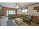 Cozy living room with paneled walls, comfortable seating, a ceiling fan, and natural light at 1524 Northcrest Dr, Anderson, IN 46012