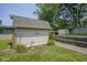 Cozy shed with a small garden, frog decoration, and stone retaining wall, offering a quaint outdoor feature at 1524 Northcrest Dr, Anderson, IN 46012