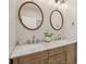 Bathroom featuring a dual sink vanity with marble countertops, round mirrors, and lots of drawer space at 1623 Hoyt Ave, Indianapolis, IN 46203